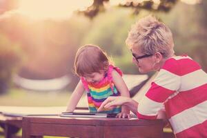 mom and her little daughter using tablet computer photo