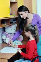 mom and girl doing homework at home photo