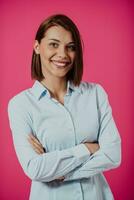 retrato Disparo de un hermosa rubio mujer de negocios en pie con brazos cruzado a aislado rosado antecedentes. foto