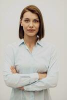 Portrait shot of a beautiful blond businesswoman standing with arms crossed at isolated white background. High quality photo