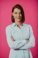 retrato Disparo de un hermosa rubio mujer de negocios en pie con brazos cruzado a aislado rosado antecedentes. foto