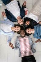 Top view of a diverse group of people lying on the floor and symbolizing togetherness photo