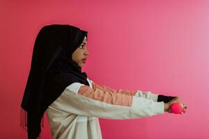 African American muslim woman promotes a healthy life, holding dumbbells in her hands photo