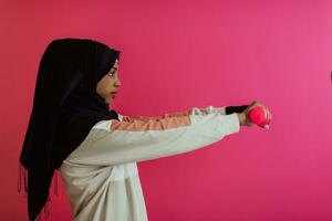 africano americano musulmán mujer promueve un sano vida, participación pesas en su manos foto