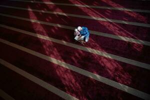 muslim prayer father and son in mosque praying and reading holly book quran together islamic education concept photo