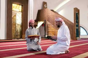 two muslim people in mosque reading quran together concept of islamic education photo