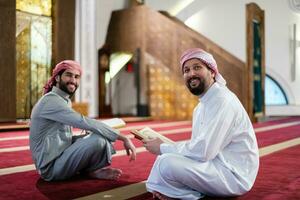 two muslim people in mosque reading quran together concept of islamic education photo