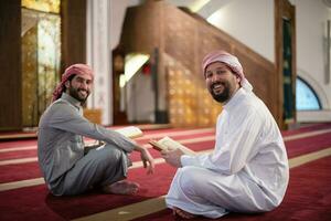 two muslim people in mosque reading quran together concept of islamic education photo