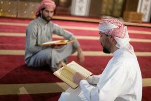 two muslim people in mosque reading quran together concept of islamic education photo