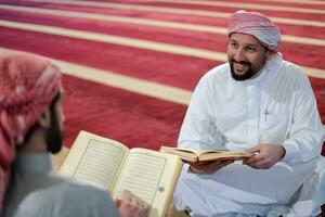 two muslim people in mosque reading quran together concept of islamic education photo