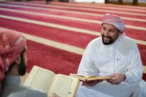 two muslim people in mosque reading quran together concept of islamic education photo