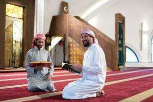 two muslim people in mosque reading quran together concept of islamic education photo