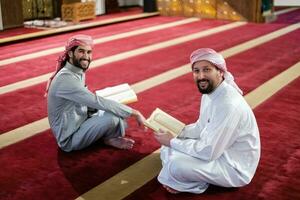 two muslim people in mosque reading quran together concept of islamic education photo