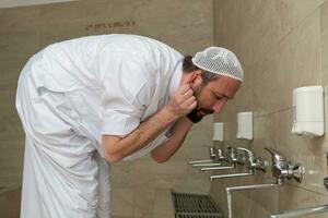 A Muslim takes ablution for prayer. Islamic religious rite photo