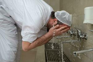 A Muslim takes ablution for prayer. Islamic religious rite photo