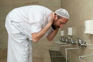 A Muslim takes ablution for prayer. Islamic religious rite photo