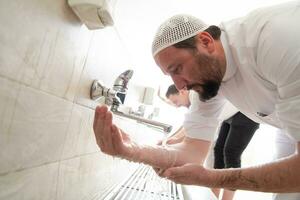 a group of Muslims take ablution for prayer. Islamic religious rite photo