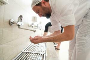 A Muslim takes ablution for prayer. Islamic religious rite photo