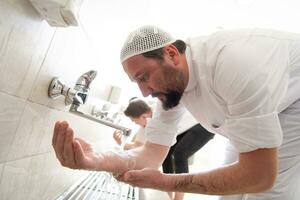 a group of Muslims take ablution for prayer. Islamic religious rite photo