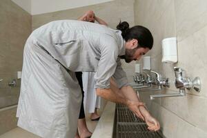 a group of Muslims take ablution for prayer. Islamic religious rite photo