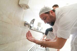 a group of Muslims take ablution for prayer. Islamic religious rite photo