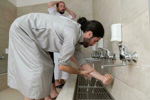 a group of Muslims take ablution for prayer. Islamic religious rite photo