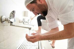 a group of Muslims take ablution for prayer. Islamic religious rite photo