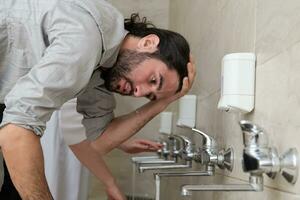 a group of Muslims take ablution for prayer. Islamic religious rite photo