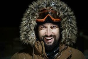 man at winter in stormy weather night  wearing warm  fur jacket photo