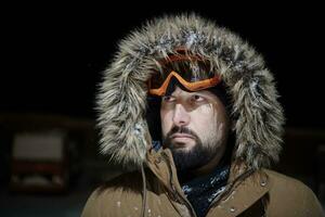 hombre en invierno en una noche tormentosa con una cálida chaqueta de piel foto