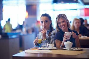 las chicas toman una taza de café en el restaurante foto