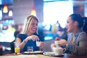 las chicas toman una taza de café en el restaurante foto