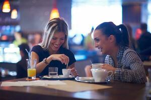 las chicas toman una taza de café en el restaurante foto