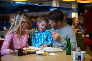 family having lunch in shopping mall photo