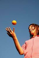 girl balancing orange in air photo