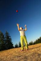 happy girl throwing apple outside photo