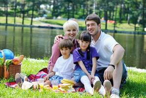 Happy family playing together in a picnic outdoors photo