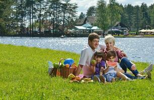 Happy family playing together in a picnic outdoors photo