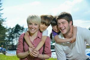 familia joven feliz divertirse al aire libre foto