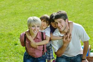 familia joven feliz divertirse al aire libre foto