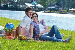 feliz pareja joven haciendo un picnic al aire libre foto