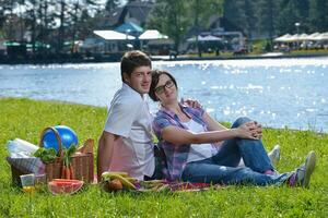 feliz pareja joven haciendo un picnic al aire libre foto