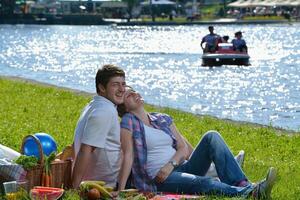 feliz pareja joven haciendo un picnic al aire libre foto