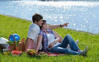 feliz pareja joven haciendo un picnic al aire libre foto