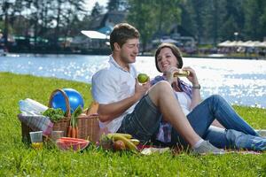 happy young couple having a picnic outdoor photo