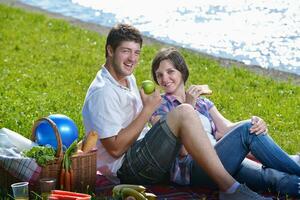 feliz pareja joven haciendo un picnic al aire libre foto