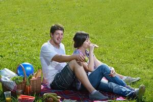 feliz pareja joven haciendo un picnic al aire libre foto