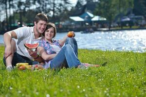 feliz pareja joven haciendo un picnic al aire libre foto