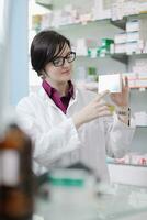 Farmacéutico químico mujer de pie en farmacia droguería foto