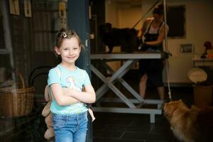 little cute girl standing in front of beauty salon for animals photo